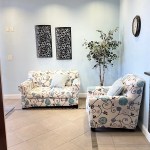 Similar to the previous view, but including a large artificial potted plant and two pieces of dark textured wall art