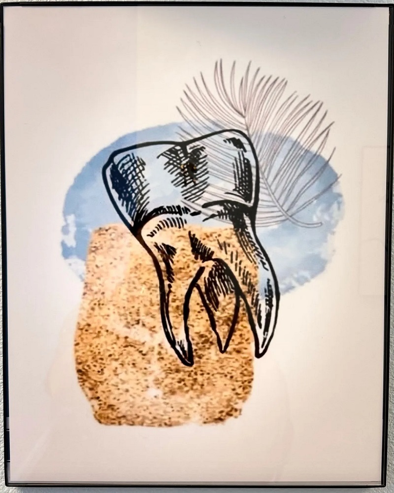 A framed piece of modern art featuring a stylized black-and-white sketch of a tooth over abstract blue and tan watercolor shapes